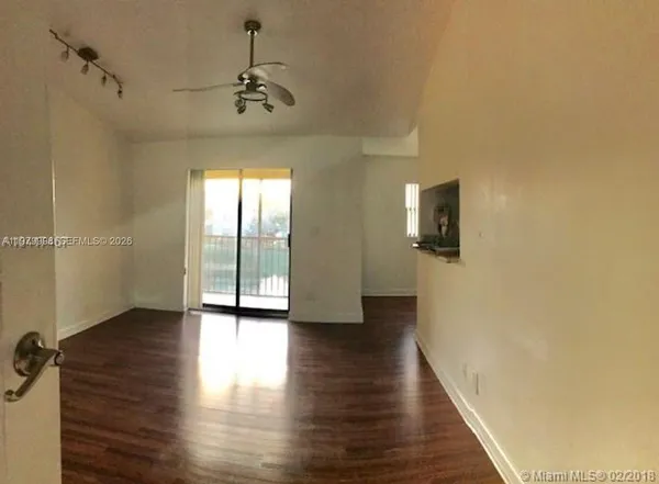 a view of a hallway with wooden floor and a chandelier
