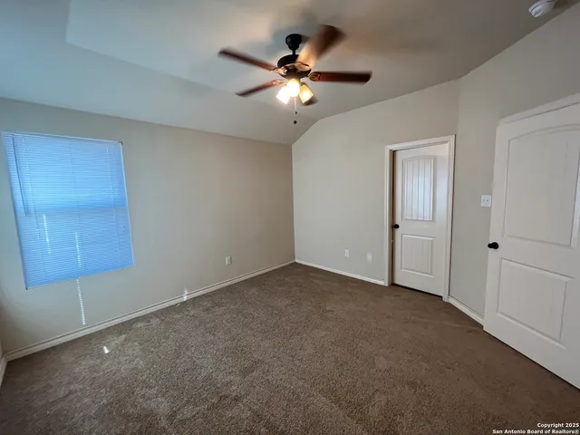 a view of an empty room with a ceiling fan