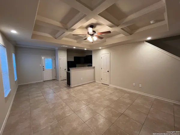 a view of a livingroom with a kitchen and a ceiling fan