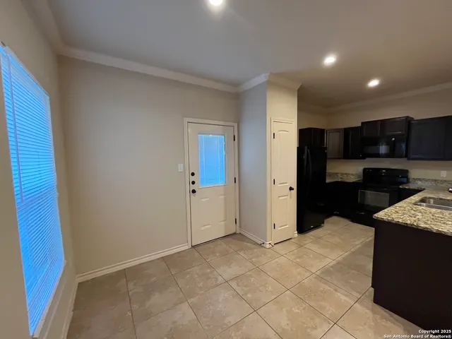 a kitchen with stainless steel appliances kitchen island granite countertop a refrigerator and a sink
