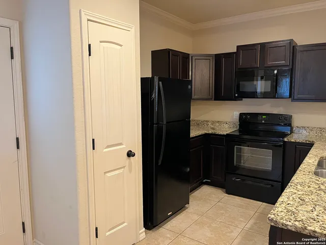 a kitchen with granite countertop stainless steel appliances and wooden cabinets