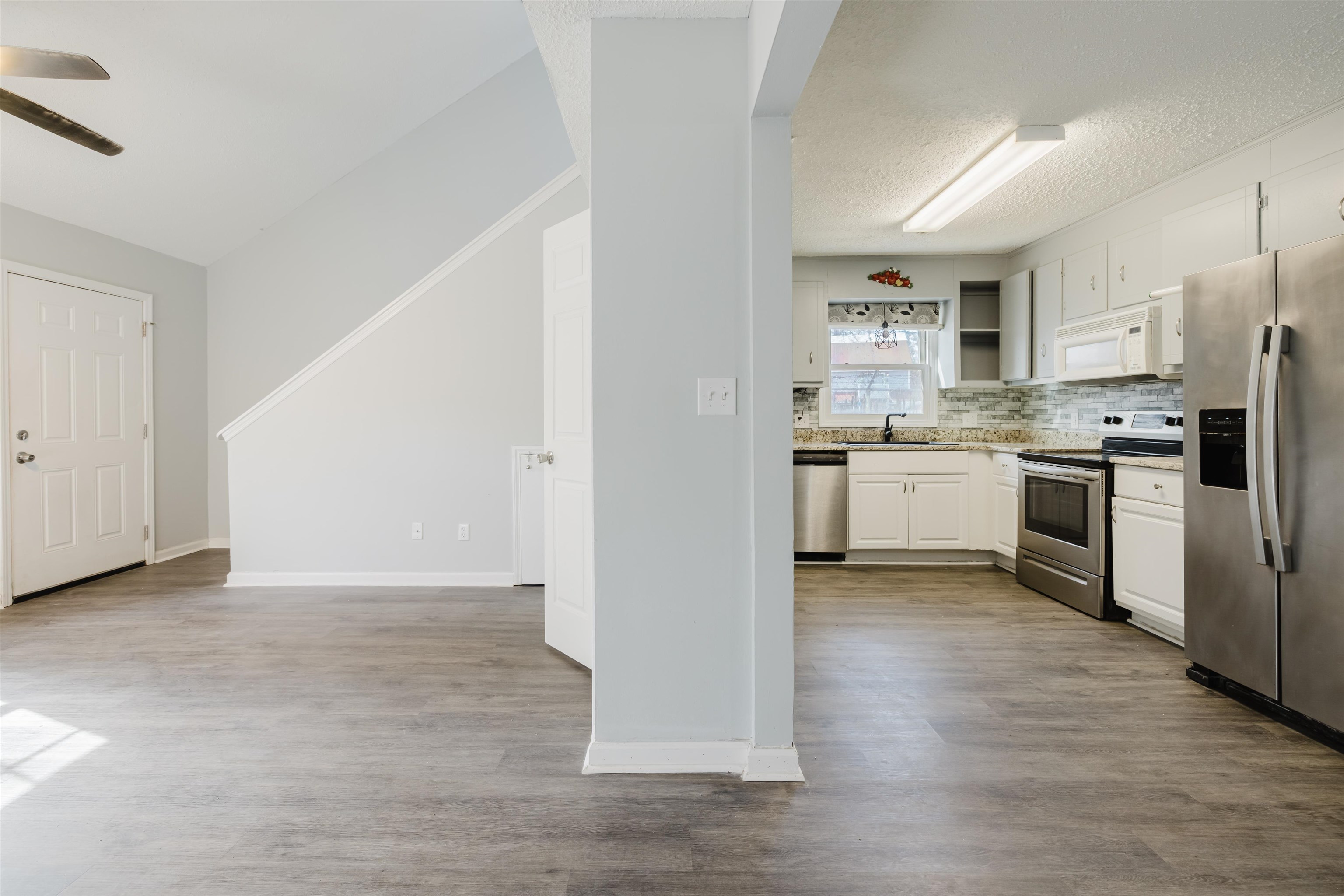 90 Freedom Way Myrtle Beach, SC 29577 - Photo 2 of 16 Kitchen with appliances with stainless steel finishes, white cabinets, decorative backsplash, open shelves, and dark wood finished floors