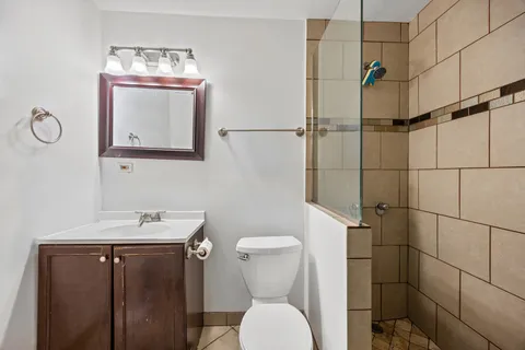a bathroom with a toilet sink vanity and mirror