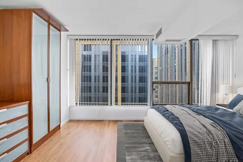 a view of a bedroom with wooden floor and stairs