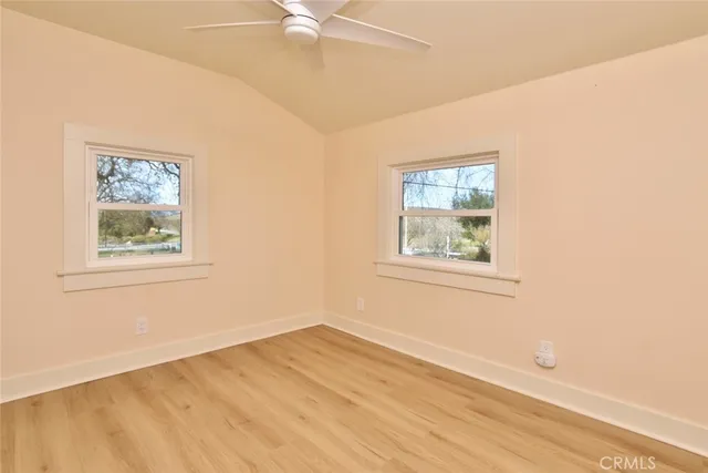 an empty room with a window and ceiling fan