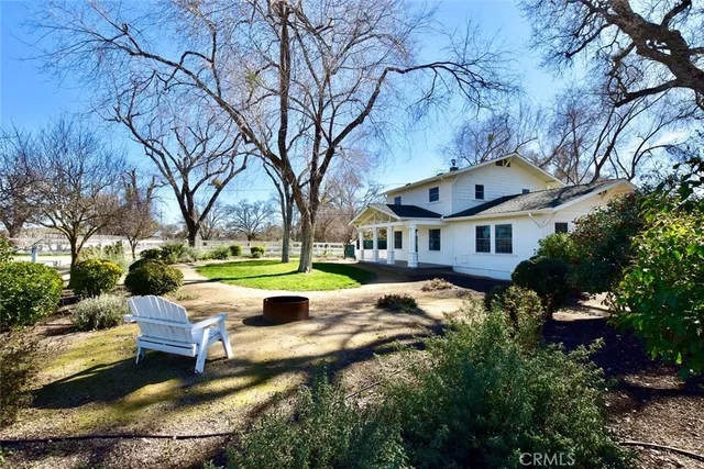 a view of swimming pool with lawn chairs and plants