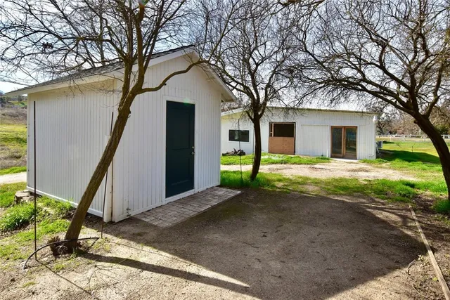 a view of a house with backyard and trees