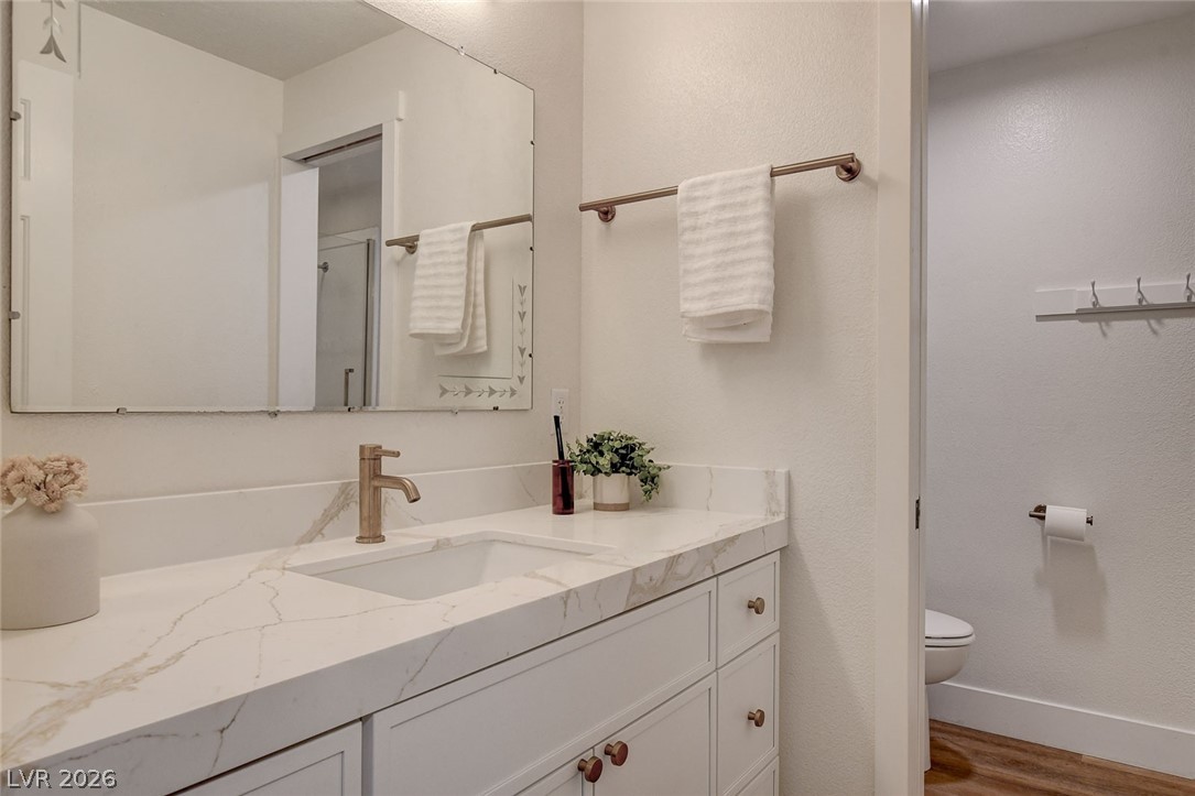 4362 Thistle Street Logandale, NV 89021 - Photo 54 of 99 A well-lit primary bathroom vanity features white cabinetry and a chic marble like countertop.