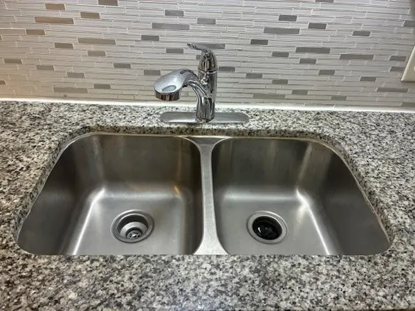 a bathroom with a granite countertop toilet and a sink