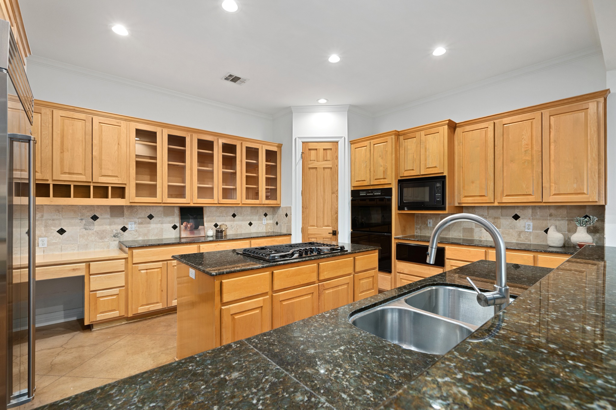 600 River Hills Road Austin, TX 78733 - Photo 17 of 40 Kitchen with large built in refrigerator, central island, wood cabinets and breakfast bar and command central kitchen desk