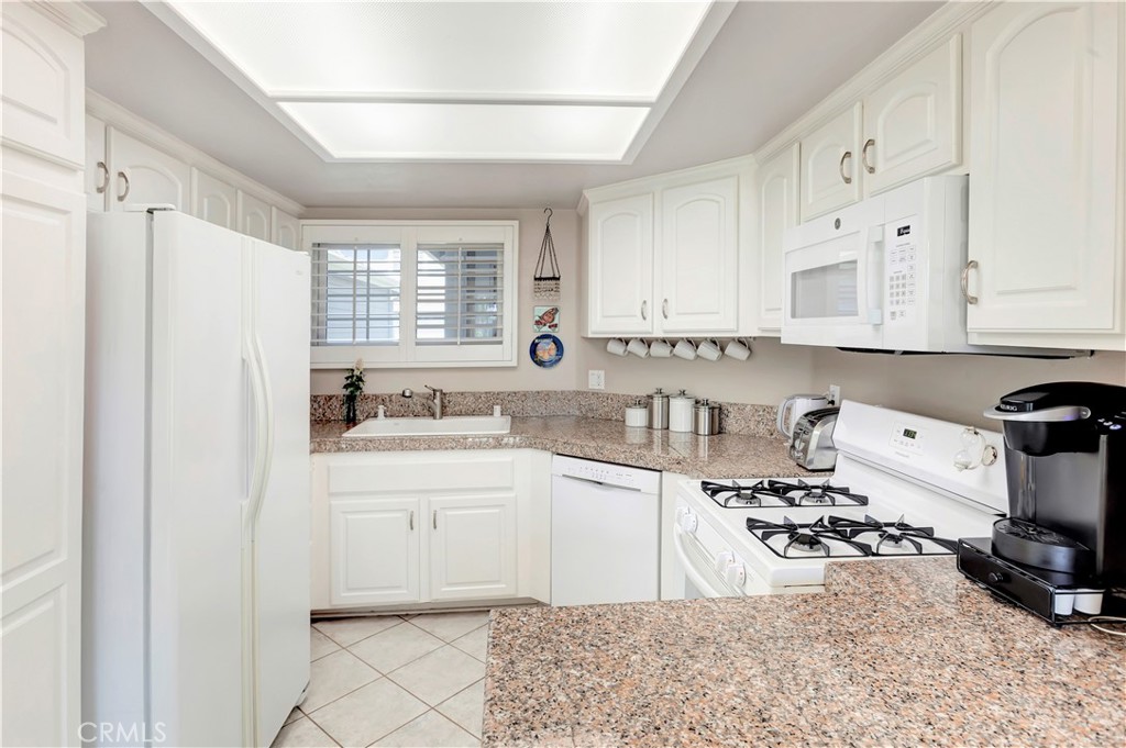 2523 Back Bay Loop, Unit 45 Costa Mesa, CA 92627 - Photo 12 of 26 Fresh, white cabinetry, granite countertops, new microwave and oven, new Anderson window and shutters