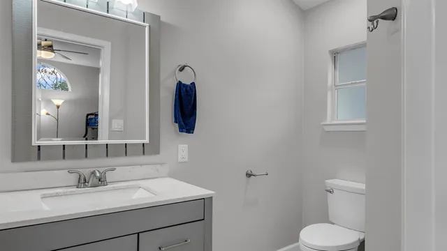 a bathroom with a toilet sink and mirror
