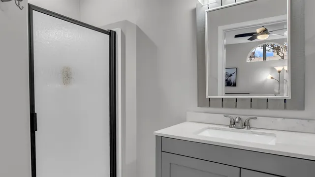 a bathroom with a granite countertop sink and a mirror