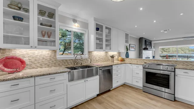 a kitchen with granite countertop stainless steel appliances a stove and a sink