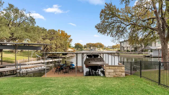 a view of a lake with lawn chairs and a fire pit