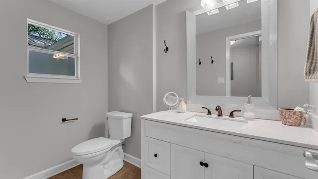 a bathroom with a toilet sink and mirror