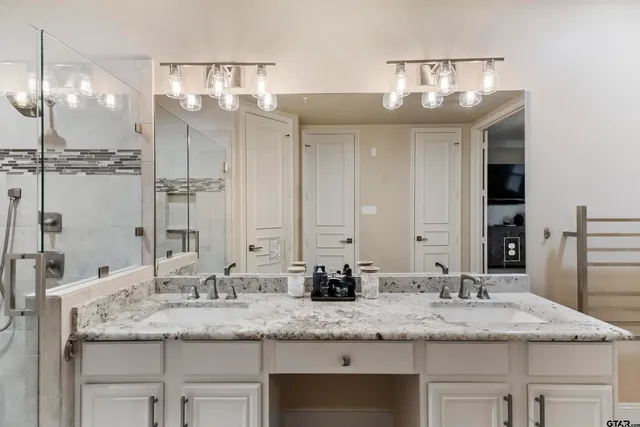 a bathroom with a granite countertop shower a mirror and a sink