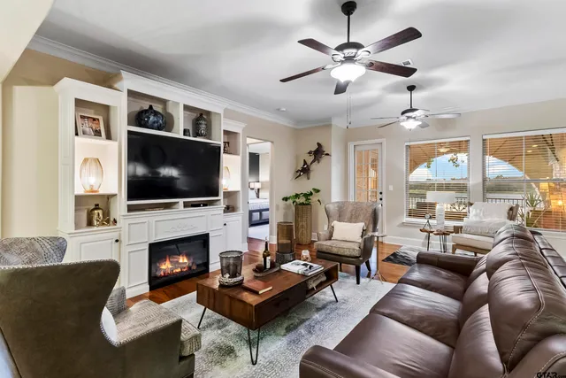 a living room with furniture a fireplace flat screen tv and couches