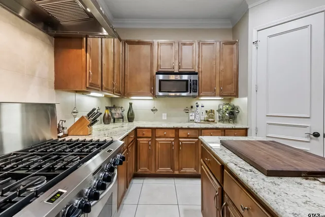 a kitchen with granite countertop a refrigerator stove and microwave