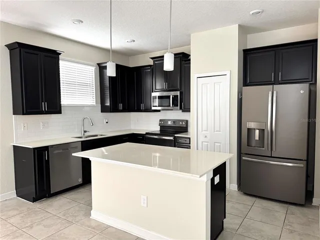 a kitchen with granite countertop a refrigerator and a sink