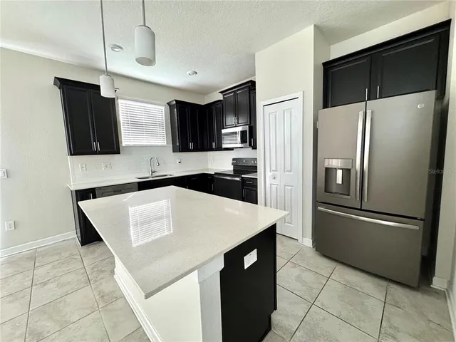 a kitchen with stainless steel appliances a refrigerator sink and microwave