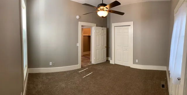 a view of wooden floor and chandelier fan in a room