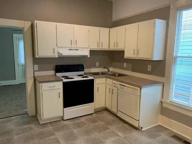 a kitchen with white cabinets and white appliances