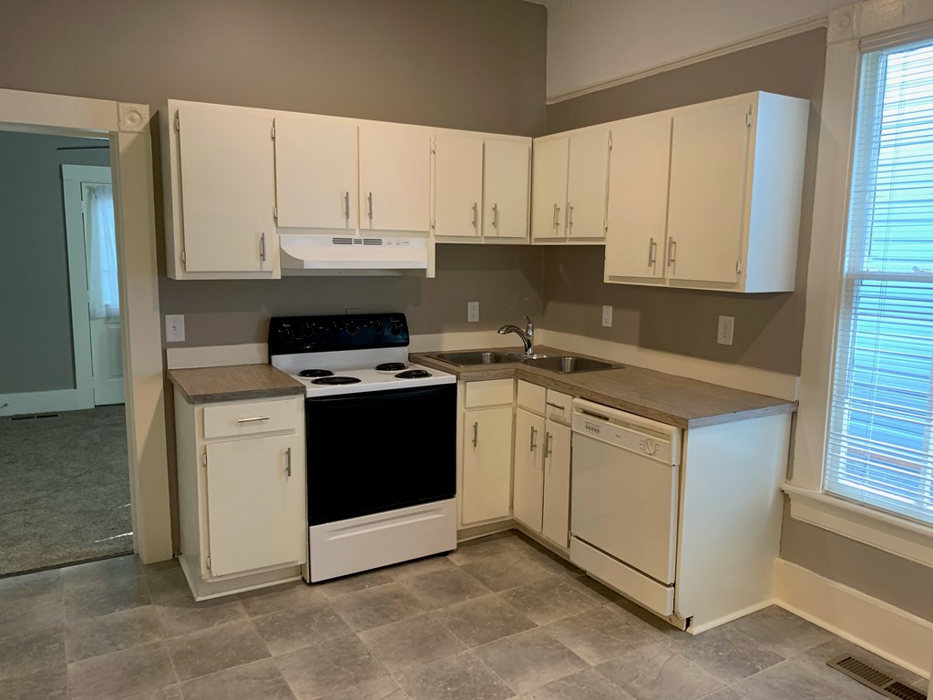 1360 Rhodes Street, Unit B Columbus, GA 31901 - Photo 6 of 14 a kitchen with white cabinets and white appliances