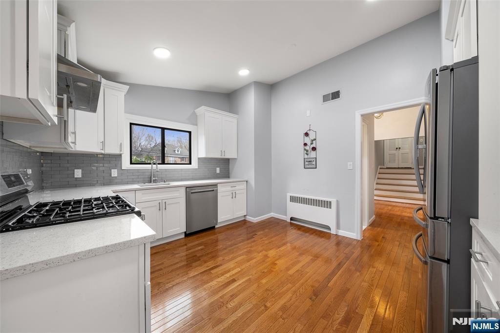 970 Soldier Hill Road Emerson, NJ 07630 - Photo 11 of 37 a kitchen with white cabinets and appliances