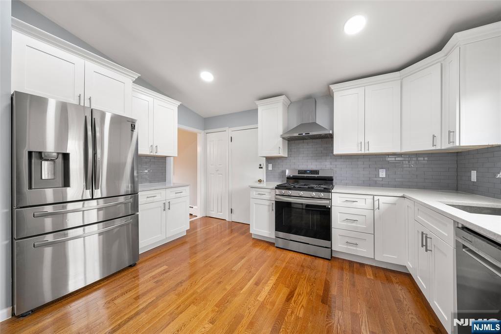 970 Soldier Hill Road Emerson, NJ 07630 - Photo 14 of 37 a kitchen with stainless steel appliances granite countertop a refrigerator stove and white cabinets