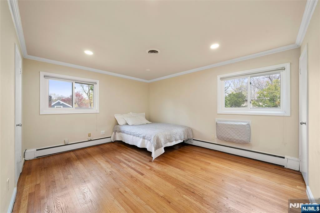 970 Soldier Hill Road Emerson, NJ 07630 - Photo 16 of 37 a spacious bedroom with a bed and wooden floor
