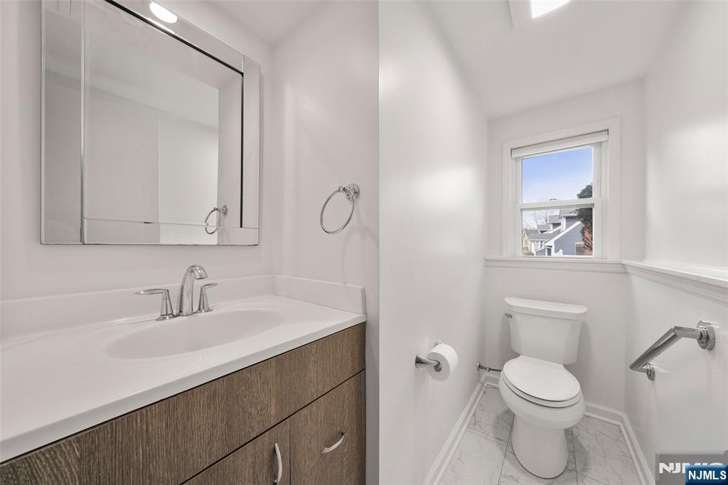970 Soldier Hill Road Emerson, NJ 07630 - Photo 25 of 37 a bathroom with a toilet a sink a mirror and vanity