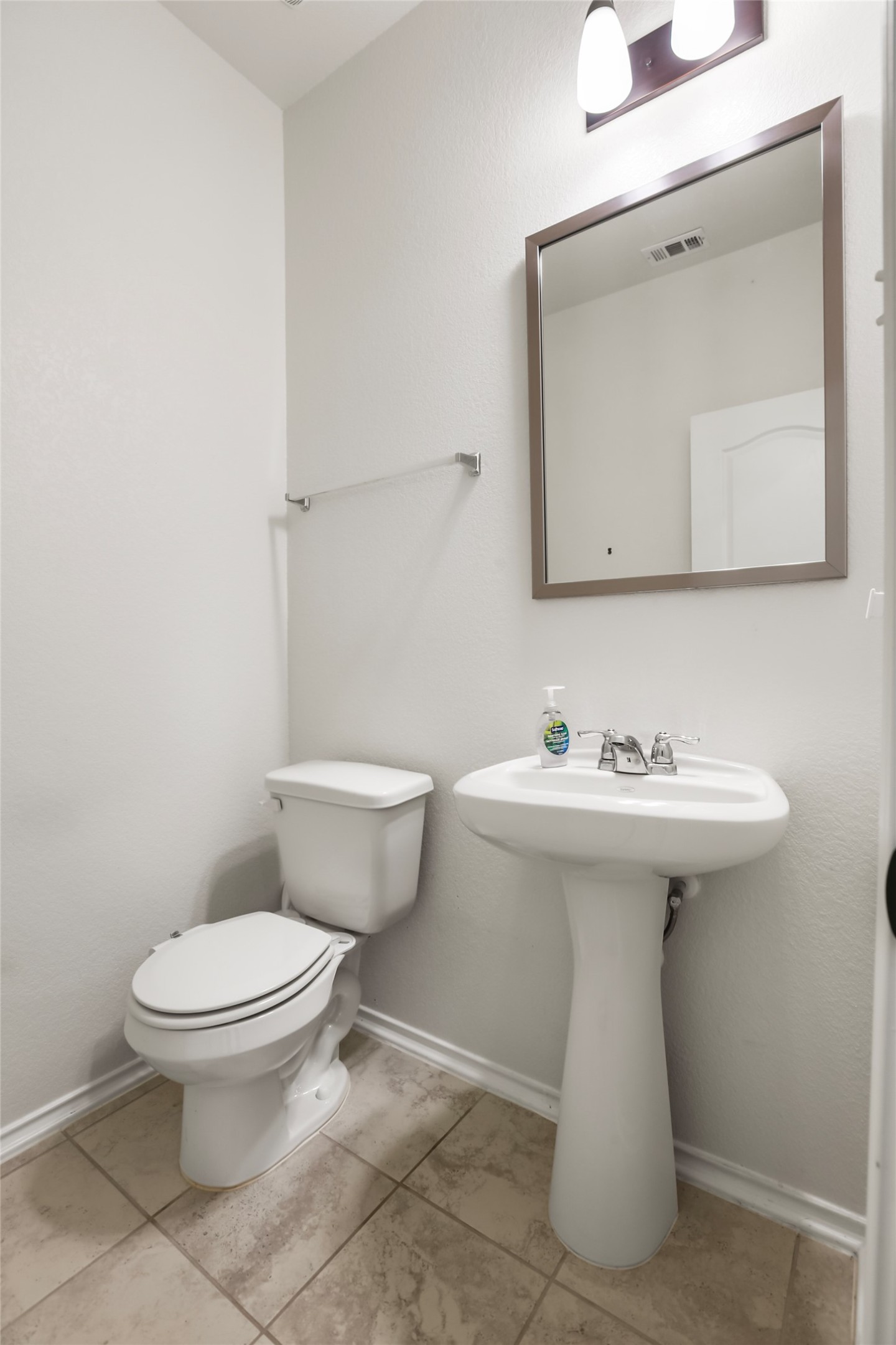 18917 Rushmore Street Manor, TX 78653 - Photo 9 of 28 a white toilet sitting next to a bathroom sink