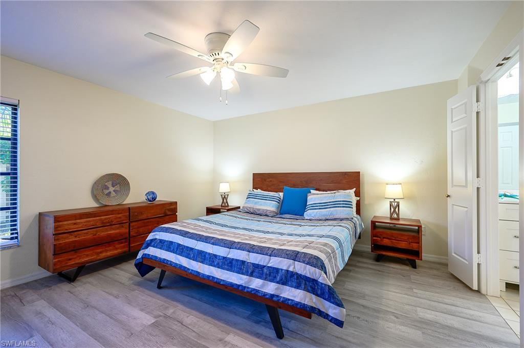 833 Reef Point Circle Naples, FL 34108 - Photo 16 of 41 Bedroom featuring multiple windows, light wood-type flooring, and ceiling fan