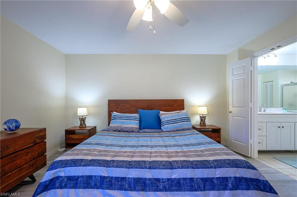833 Reef Point Circle Naples, FL 34108 - Photo 17 of 41 Bedroom featuring ceiling fan, wood finished floors, and ensuite bathroom
