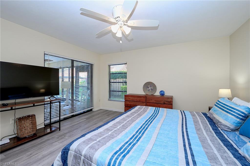 833 Reef Point Circle Naples, FL 34108 - Photo 19 of 41 Bedroom with wood finished floors, a ceiling fan, and access to exterior