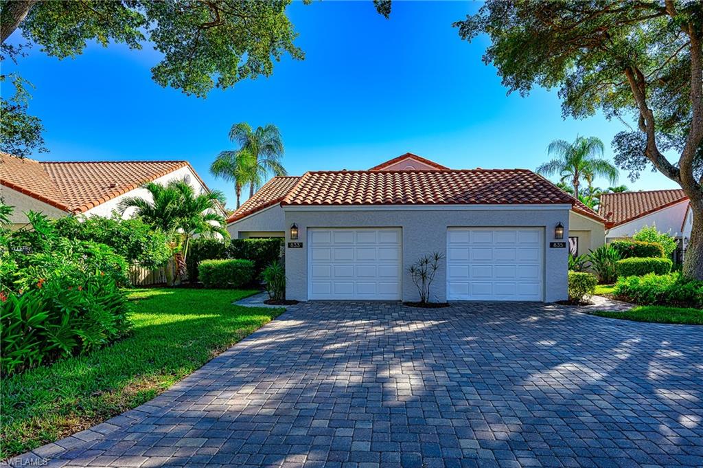 833 Reef Point Circle Naples, FL 34108 - Photo 25 of 41 View of front of house with a tile roof, stucco siding, decorative driveway, a garage, and a front lawn