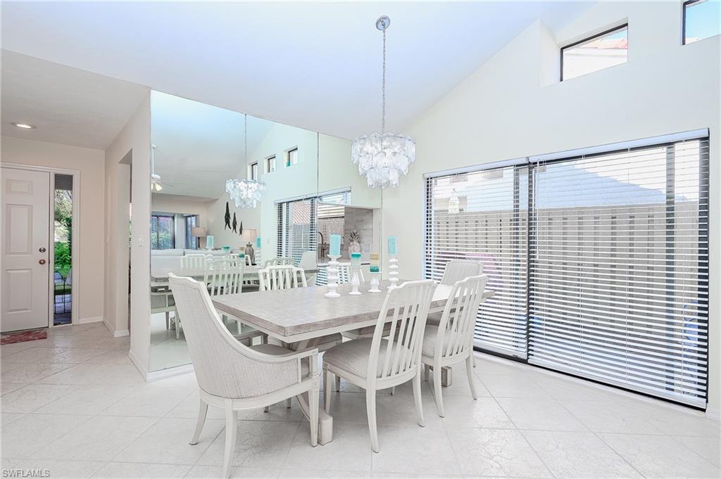 833 Reef Point Circle Naples, FL 34108 - Photo 9 of 41 Dining room with plenty of natural light, a chandelier, lofted ceiling, and light tile patterned flooring