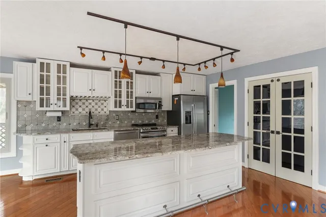 a kitchen with stainless steel appliances granite countertop a sink and cabinets