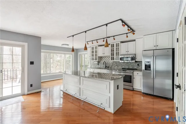 a kitchen with stainless steel appliances a stove a refrigerator and a sink with cabinets