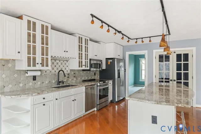 a kitchen with stainless steel appliances granite countertop a sink and cabinets