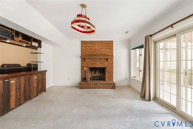 a view of an empty room with a fireplace and a window