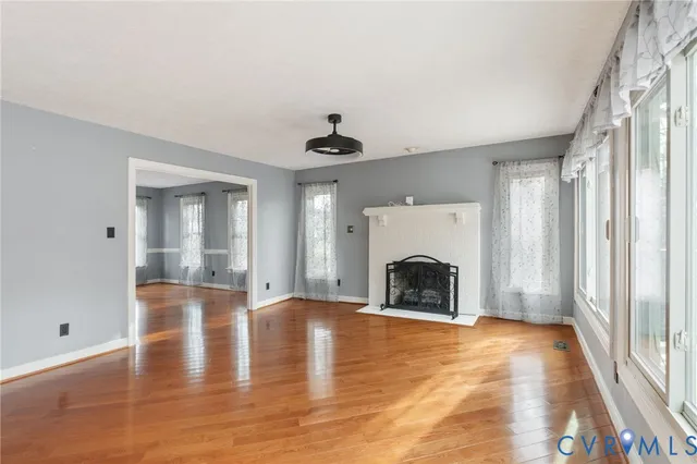 a view of an empty room with window and fire place