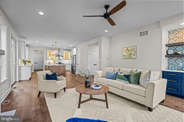 a living room with furniture and a view of kitchen