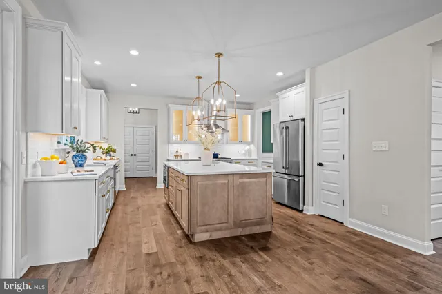 a kitchen with a refrigerator sink and wooden floor