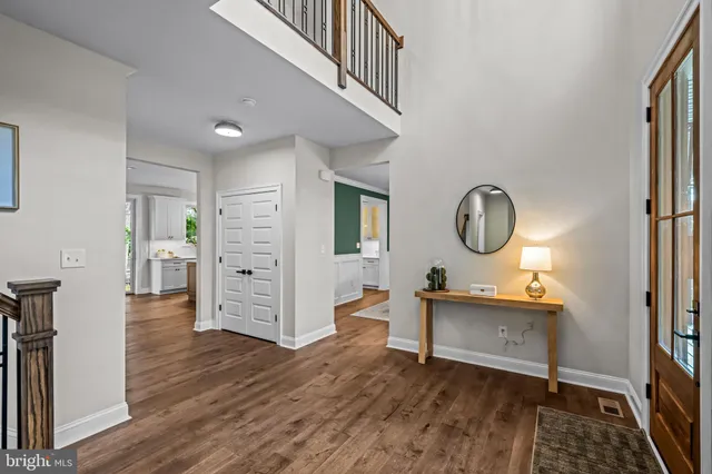 a view of a hallway with wooden floor windows and a living room
