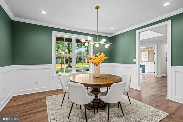 a dining room with furniture wooden floor a chandelier and a rug