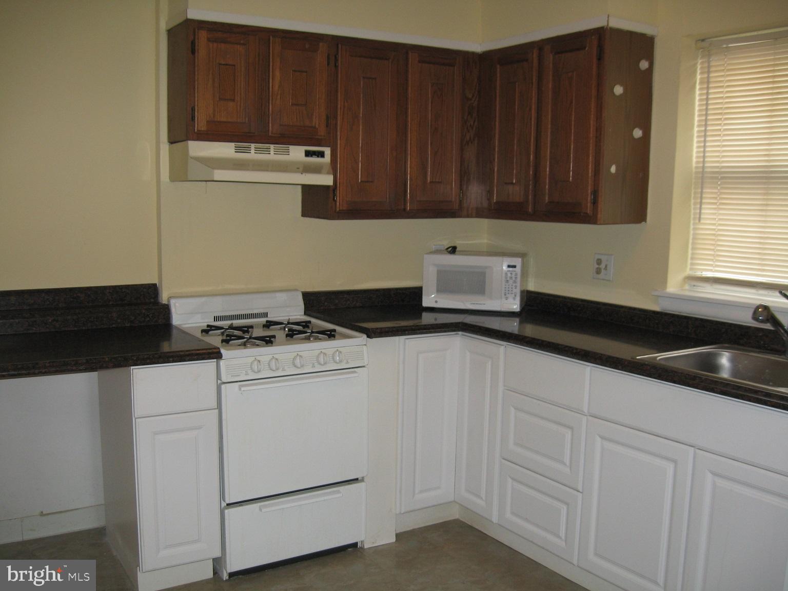 1048 South Street, Unit 3 Philadelphia, PA 19147 - Photo 3 of 9 a kitchen with granite countertop cabinets and white appliances