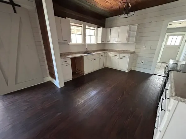 a kitchen with a sink wooden floor and a window