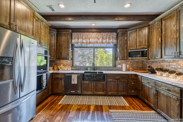 a kitchen with stainless steel appliances granite countertop a stove a sink and a refrigerator